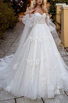 a woman in a white wedding dress posing for the camera with her veil over her head