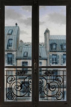 an open window with a view of buildings through it and snow falling on the ground