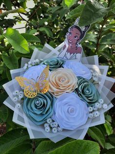 a bouquet of flowers with a paper cut out of the face of disney princess pooh