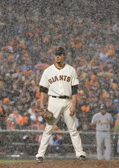 a baseball player is standing in the rain