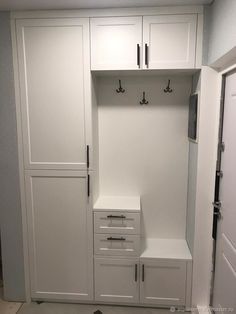 an empty white closet with drawers and cabinets