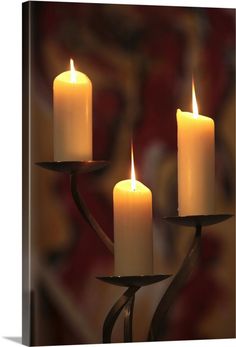 three candles are lit on a candle holder