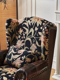 a chair that is sitting in front of a fireplace with a floral pattern on it