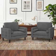 two gray chairs sitting next to each other on top of a rug in a living room