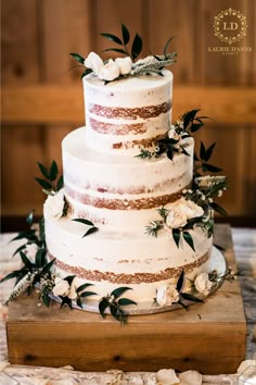 a wedding cake with white flowers and greenery