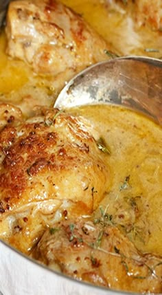 the chicken is being cooked in the pot with a ladle to stir it down