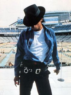 a man with a cowboy hat on standing in front of an empty stadium