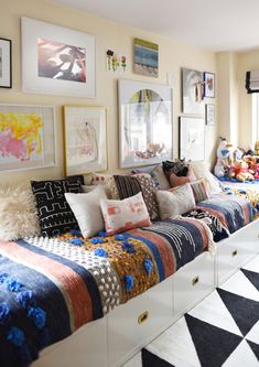 a living room filled with lots of furniture and pictures on the wall above it's windows