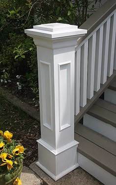 a planter with yellow flowers sitting on the steps