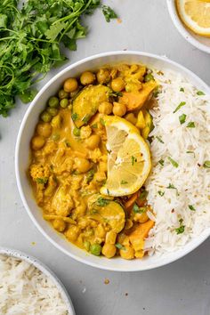 a bowl filled with rice and vegetables next to lemons, cilantro and parsley