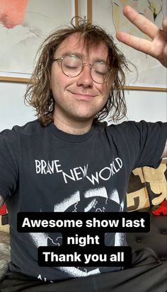 a man with long hair and glasses sitting in front of a sign that says, awesome show last night thank you all