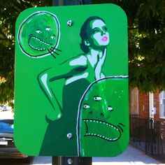 a green street sign with a drawing of a woman holding a tennis racquet