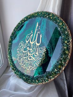 a glass plate with an arabic calligraphy on the bottom and gold trimming around it