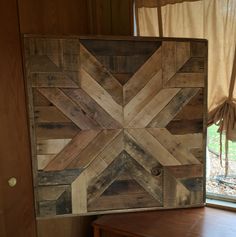 a wooden box sitting on top of a table next to a window