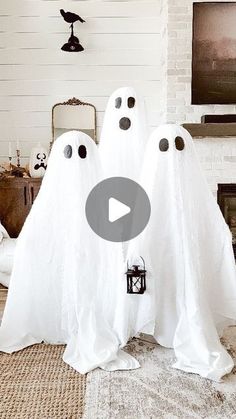 two white ghost statues sitting in front of a fireplace with eyes and noses on them