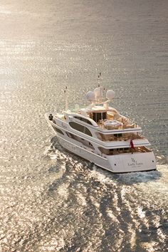 a large white boat is in the middle of the ocean with sun reflecting off it's side