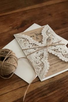 the wedding stationery is tied up with twine and lace, along with a ball of twine