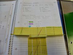 an open notebook with yellow paper on it and a ruler in front of the page