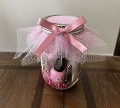 a jar filled with pink items on top of a wooden table