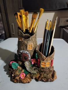 there are many brushes in the cup that is on top of a table with rocks