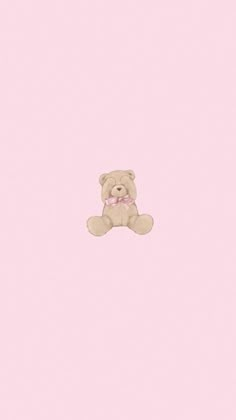 a brown teddy bear sitting on top of a pink wall