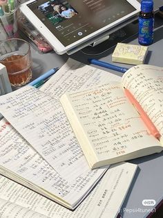 an open book sitting on top of a desk next to a laptop computer and other office supplies