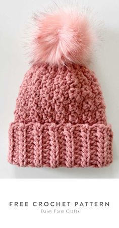 a pink knitted hat with a pom - pom on top and the text free