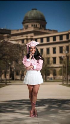 a woman in a pink shirt and white skirt posing for a photo with her hat on