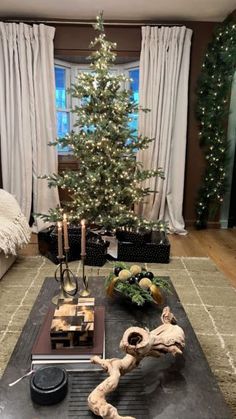 a living room with a christmas tree in the corner and decorations on the coffee table