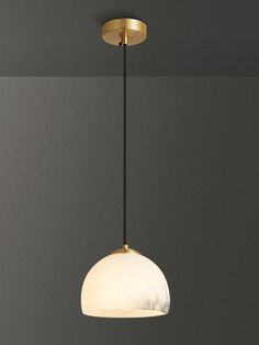 a white and gold light hanging from a ceiling fixture in a room with gray walls