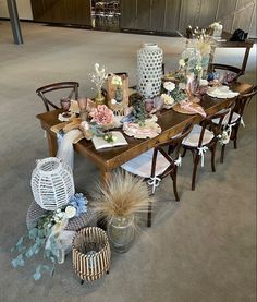 a table set up with plates and vases on top of it, surrounded by other items