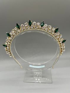 a tiara with green and white stones on it