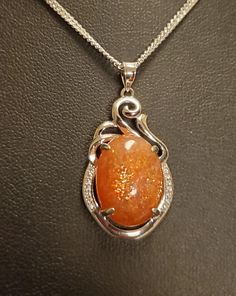 "Sparkling Natural Sunstone Necklace, 13x17mm Orange Schiller Stone, 925 Sterling Silver Swirl Top Pendant With Tiny Cubic Zirconia Trim. 20\" Sterling Chain. Chain Length Options Available By Messaging Seller At Time Of Purchase. Gift Box Included." Luxury Orange Faceted Necklace, Sunstone Necklace Pendants, Orange Gem Necklace, Luxury Orange Necklace With Natural Stones, Orange Stone Necklace, Magic Amulet Necklace, Gem Necklace Stones, Silver Oval Necklace With Sparkling Stones, Oval Stone Set Necklaces For Anniversary