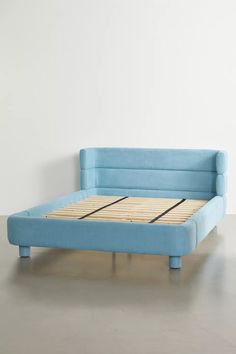 a blue bed frame sitting on top of a white floor