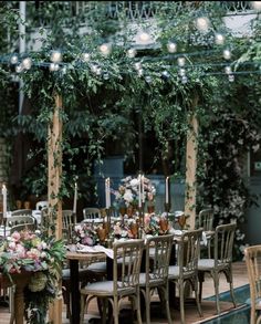 an outdoor dining area with tables, chairs and lights strung from the ceiling over them