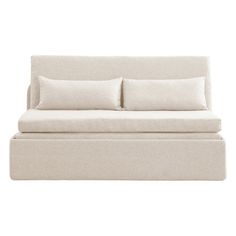 a white couch with two pillows on the back and one pillow sitting on top of it