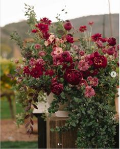 a vase filled with lots of flowers on top of a table