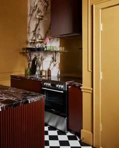 a kitchen with black and white checkered flooring next to a stove top oven