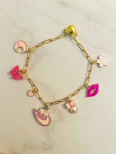 This 7 inch charm bracelet features fun pink charms and a magnetic clasp! Perfect for the pink girlies! Trendy Pink Jewelry With Charms, Trendy Pink Charm Bracelets, Trendy Pink Bracelets With Charms, Trendy Pink Metal Bracelets, Trendy Pink Metal Bracelet, Playful Pink Charm Bracelet For Birthday, Pink Fun Charm Bracelet, Pink Novelty Bracelets With Charms, Playful Pink Charm Bracelets