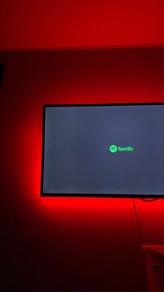 a flat screen tv sitting on top of a red wall