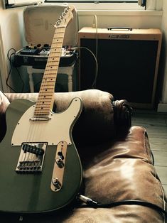 an electric guitar sitting on top of a couch