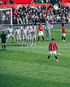 a group of soccer players standing on top of a field next to each other in front of a crowd