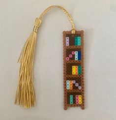 a bookmark made out of beads with a tassel hanging from it