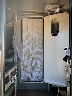 the inside of a camper with curtains and towels hanging on it's side