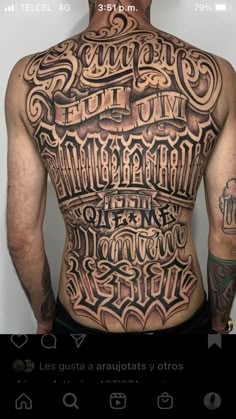 the back of a man's upper body with tattoos on his chest and arms