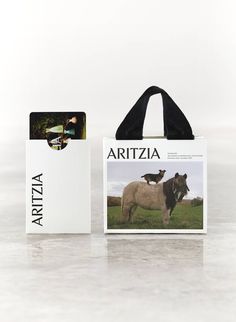 an animal is standing in the grass next to a shopping bag and a card holder