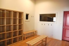 a wooden bench sitting in front of a book shelf on top of a hard wood floor