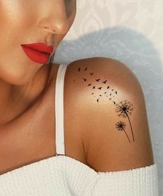 a woman with a dandelion tattoo on her shoulder and red lipstick is looking at the camera