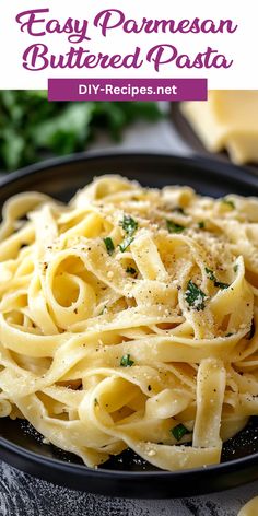 pasta with parmesan cheese and herbs in a black bowl on top of a table