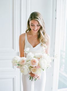 a woman holding a bouquet of white and pink flowers